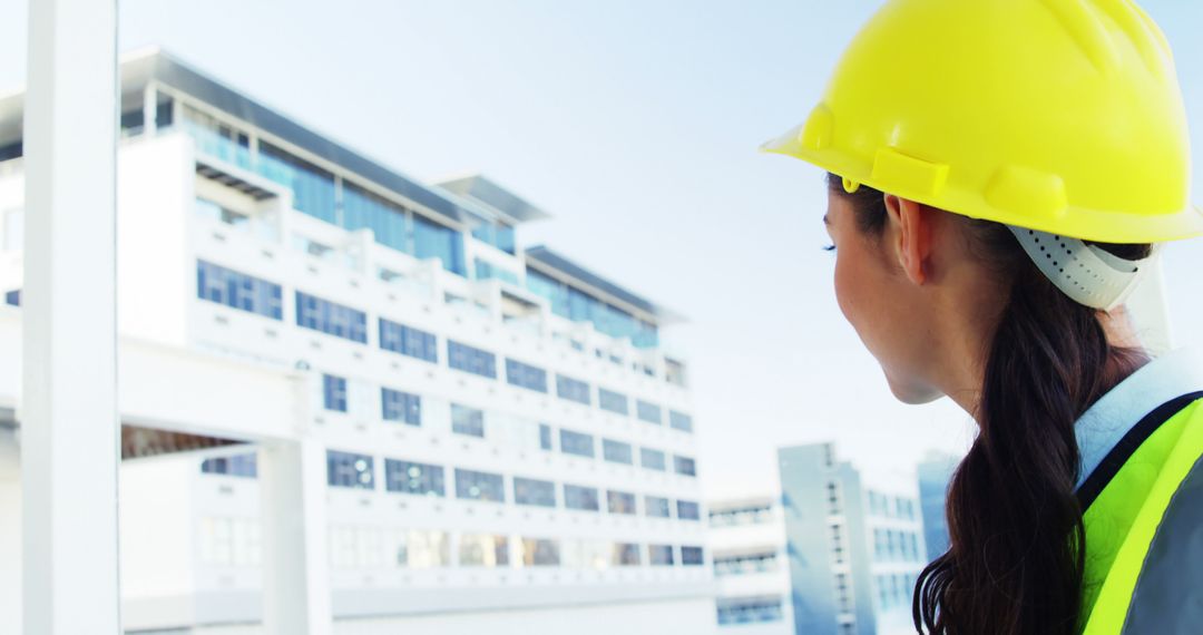 Female Construction Worker Overlooking Modern Building Project - Free Images, Stock Photos and Pictures on Pikwizard.com