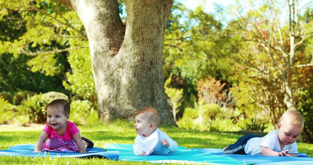 Cute Babies Playing on Mats Outdoors with Lush Greenery - Free Images, Stock Photos and Pictures on Pikwizard.com