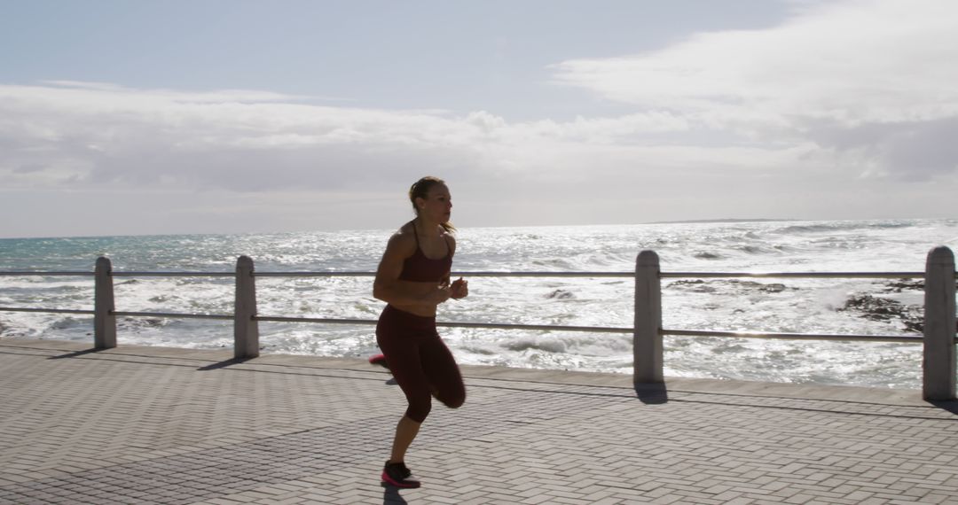 Woman Jogging Along Seaside Promenade on Cloudy Day - Free Images, Stock Photos and Pictures on Pikwizard.com