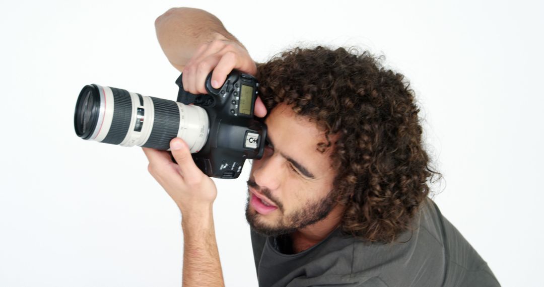 Young Photographer with Curly Hair Taking a Picture - Free Images, Stock Photos and Pictures on Pikwizard.com