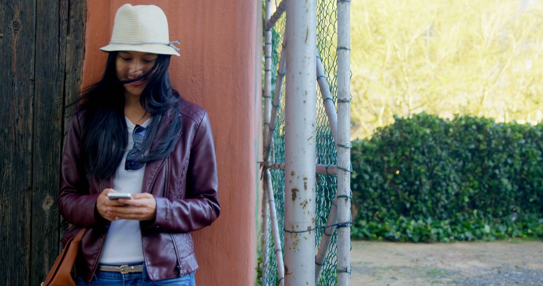 Young Woman with Hat Texting on Phone Outdoors - Free Images, Stock Photos and Pictures on Pikwizard.com