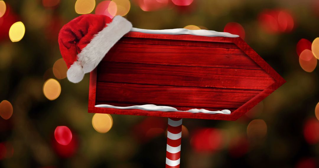 Christmas Arrow Sign with Santa Hat and Festive Bokeh Lights
