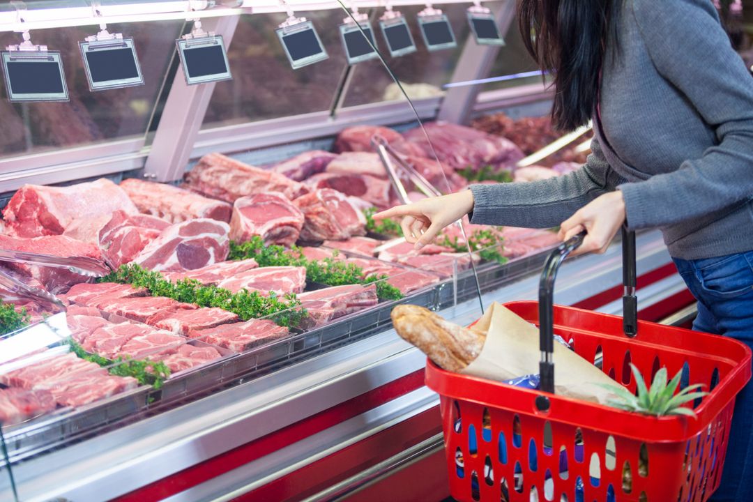 Woman pointing at meat in display - Free Images, Stock Photos and Pictures on Pikwizard.com