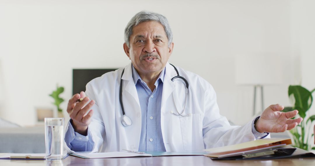 Senior Male Doctor Explaining at Desk with Stethoscope - Free Images, Stock Photos and Pictures on Pikwizard.com