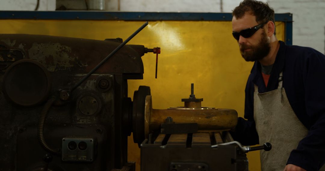 Factory worker inspecting industrial machine in workshop - Free Images, Stock Photos and Pictures on Pikwizard.com