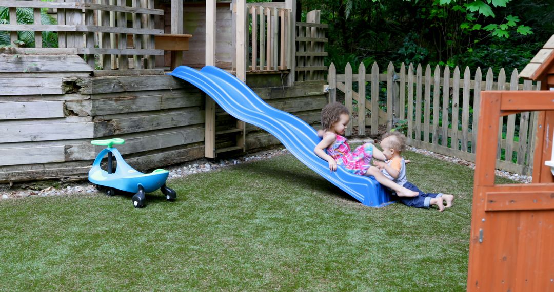 Children Sharing a Moment on Backyard Slide Playground - Free Images, Stock Photos and Pictures on Pikwizard.com