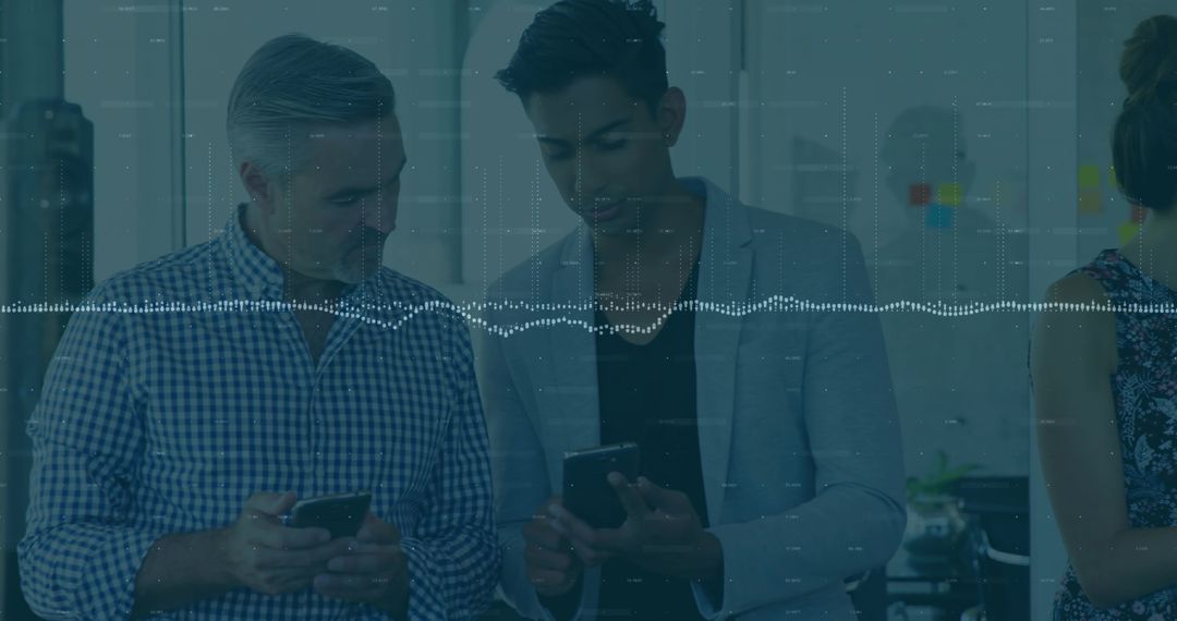 Business Professionals Comparing Mobile Devices in Modern Office