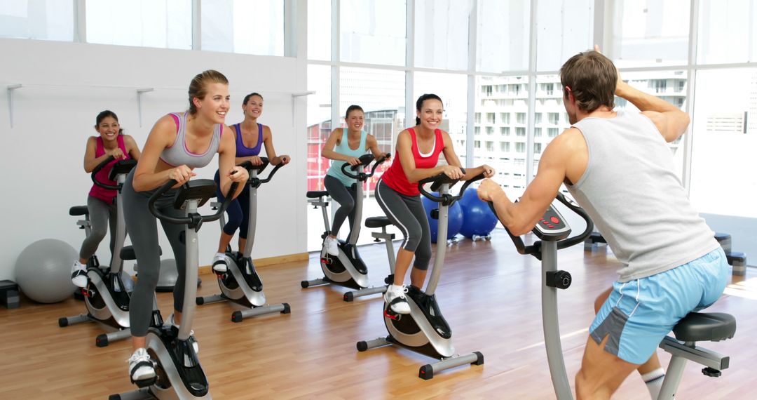 Group of Women Participating in Indoor Cycling Class with Instructor - Free Images, Stock Photos and Pictures on Pikwizard.com