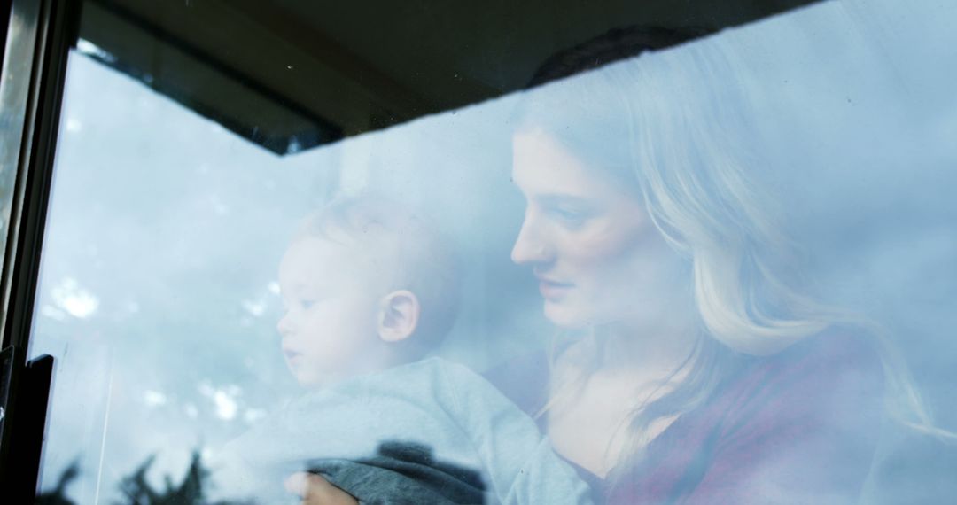 Mother Holding Baby by Foggy Window Reflecting Sky - Free Images, Stock Photos and Pictures on Pikwizard.com