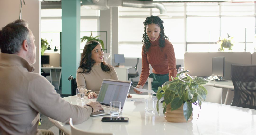 Diverse team collaborating around meeting table in bright open-plan office