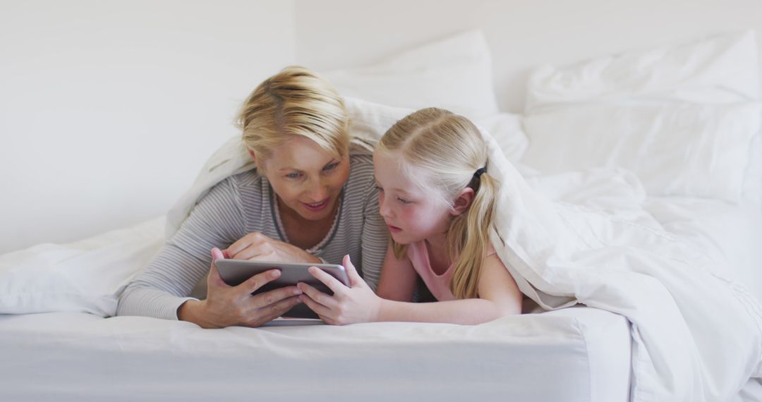 Mother and Daughter Enjoy Digital Time Together in Bed - Free Images, Stock Photos and Pictures on Pikwizard.com