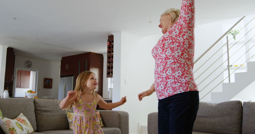 Happy Senior Grandmother Dancing with Granddaughter in Living Room - Free Images, Stock Photos and Pictures on Pikwizard.com