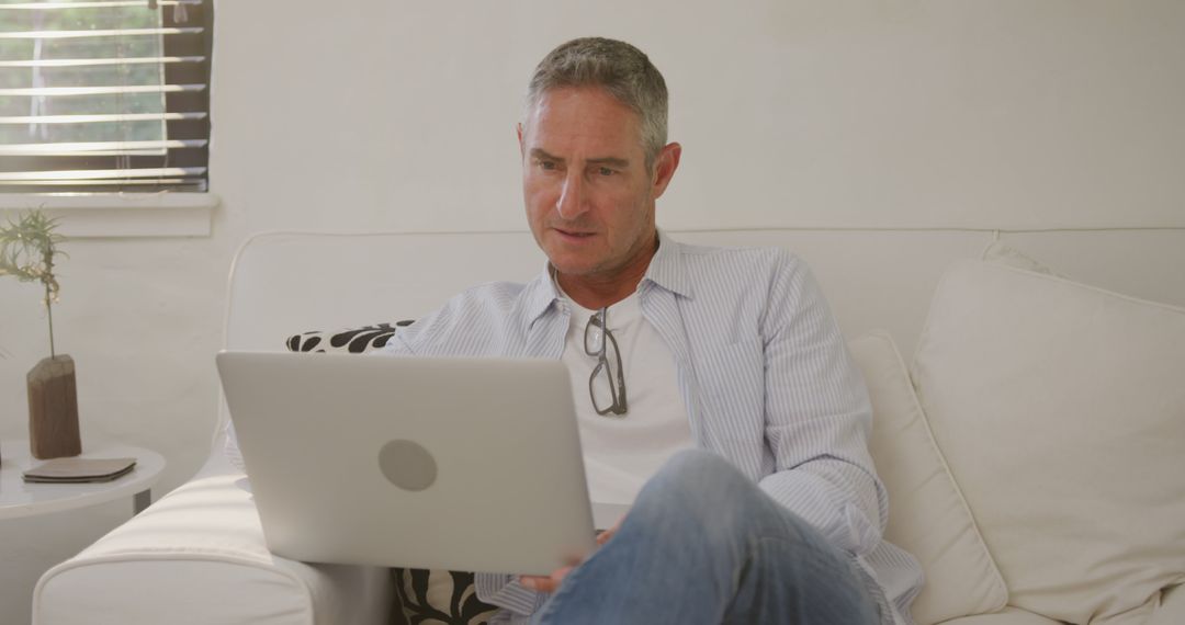 Mature Man Relaxing at Home Using Laptop and Reviewing Work - Free Images, Stock Photos and Pictures on Pikwizard.com