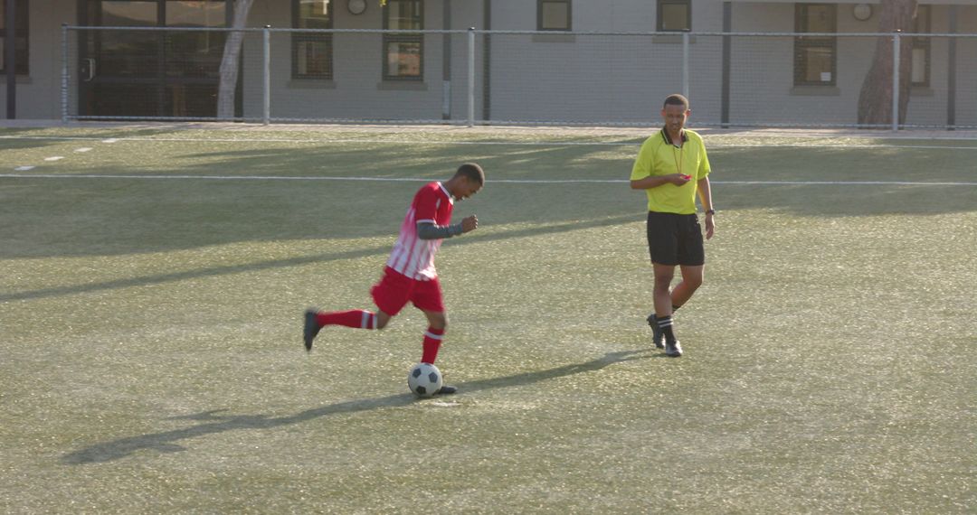 Coach Supervising Young Player During Soccer Practice