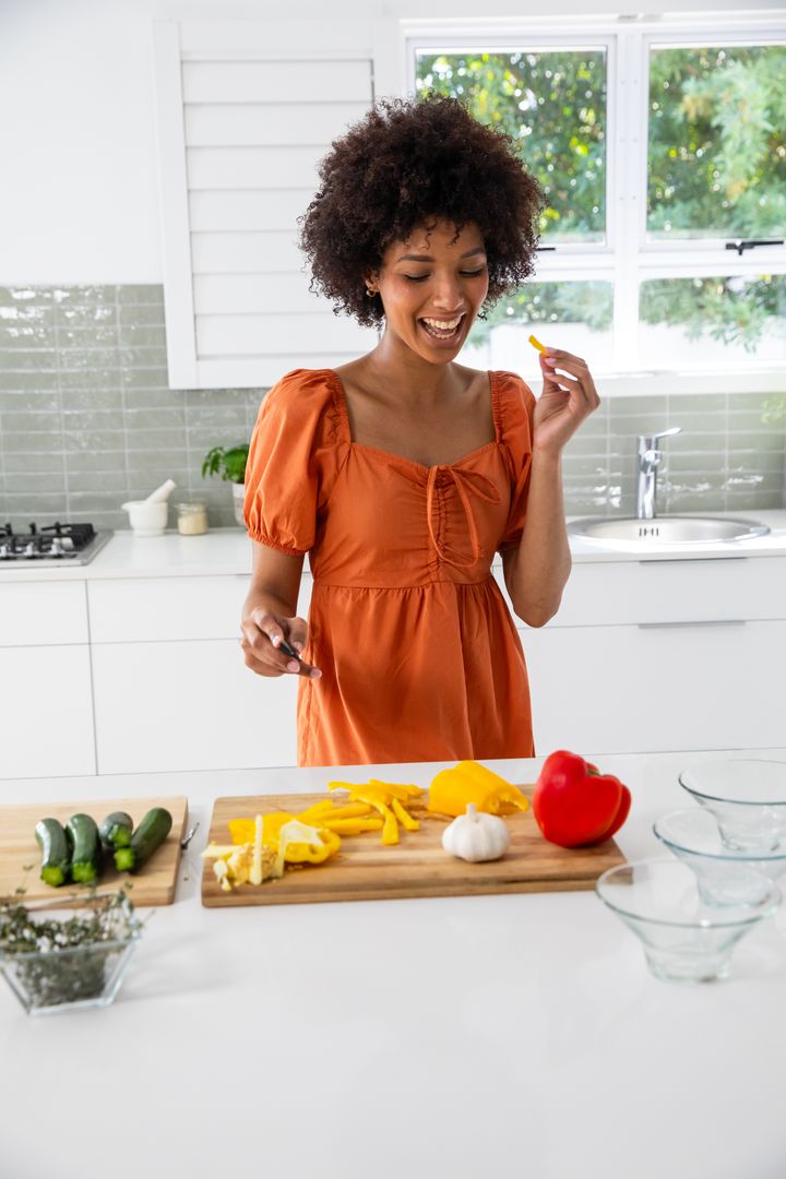Smiling Woman Slicing Vegetables in Modern Kitchen