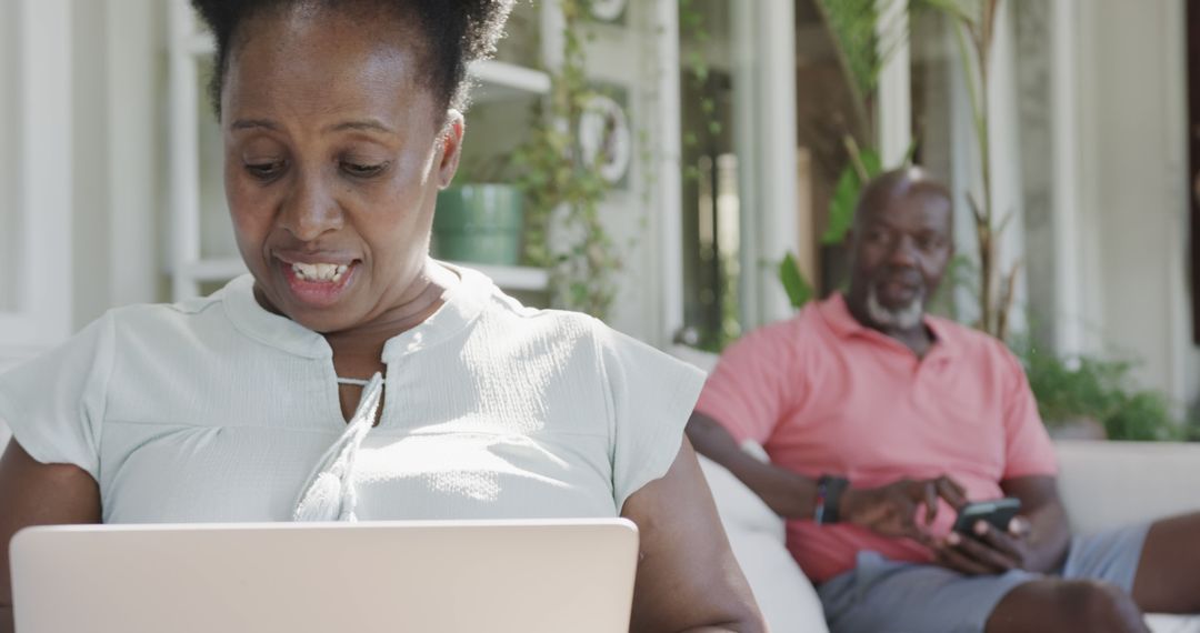 Senior African American Couple Using Laptop and Smartphone at Home