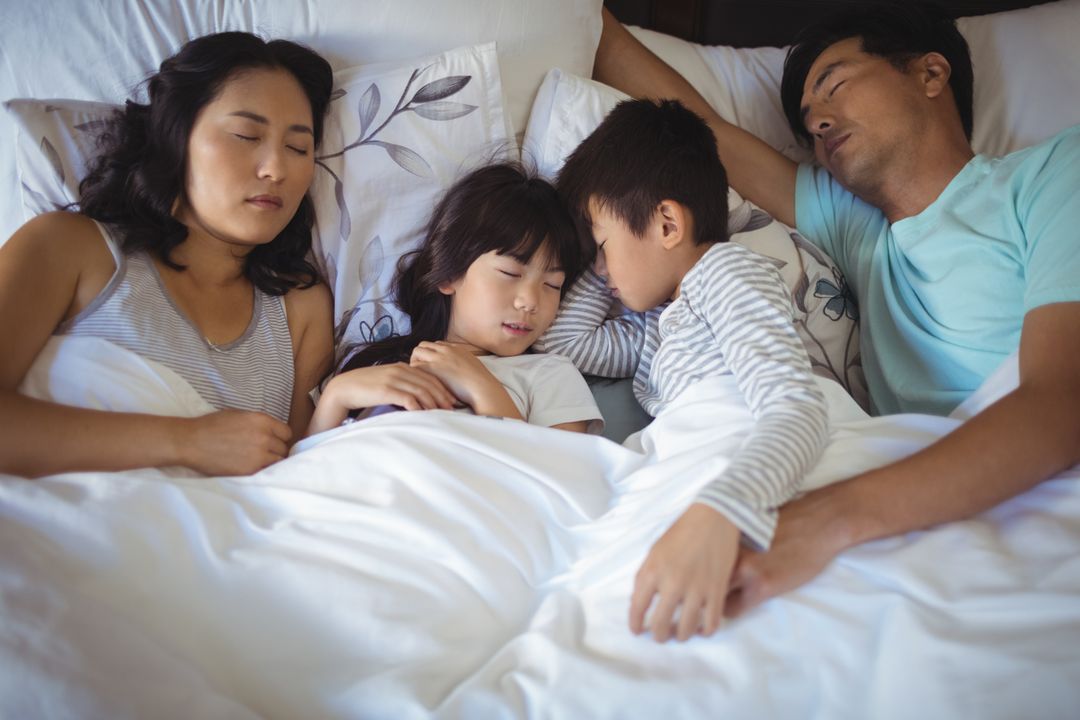 Asian Family Sleeping Peacefully in Bed Together - Free Images, Stock Photos and Pictures on Pikwizard.com