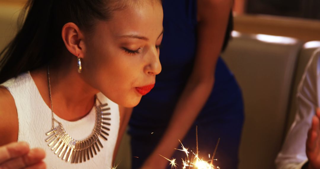 Young Woman Celebrating with Sparklers at Festive Event - Free Images, Stock Photos and Pictures on Pikwizard.com