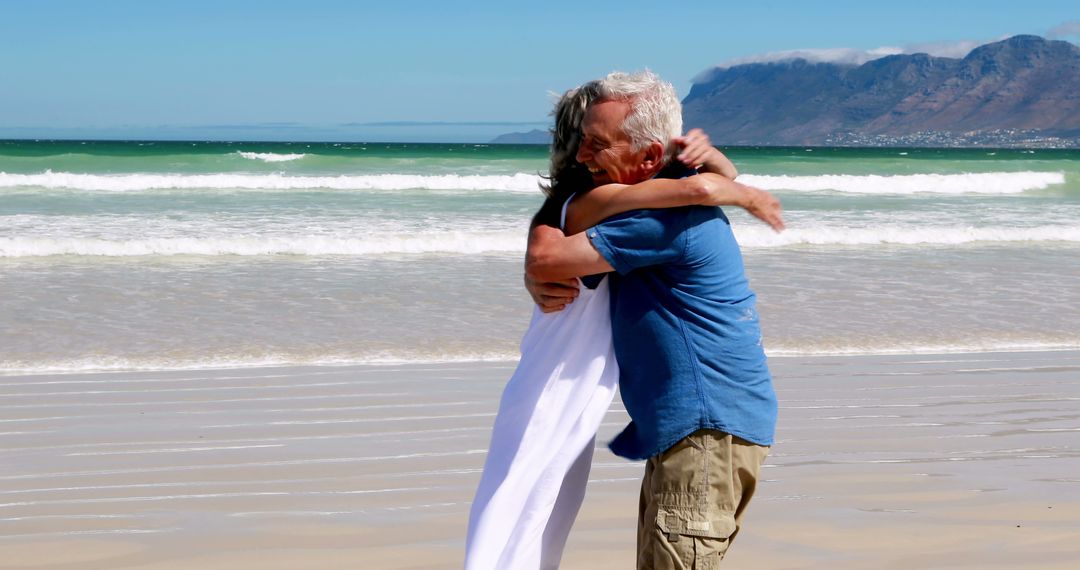 Happy Senior Couple Hugging at the Beach on Sunny Day - Free Images, Stock Photos and Pictures on Pikwizard.com