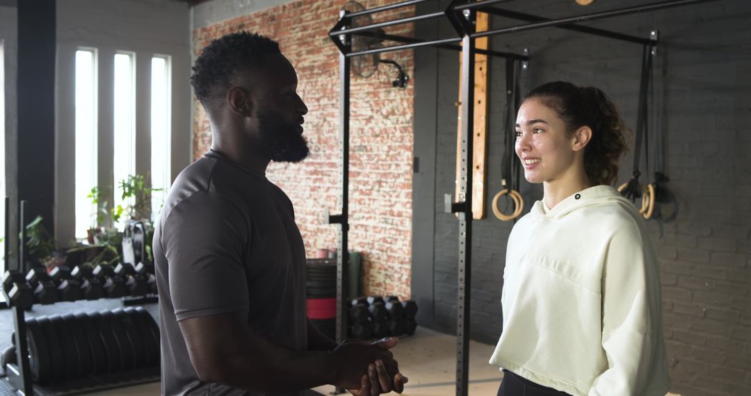 Trainer Engaging with Female Client in Gym Environment