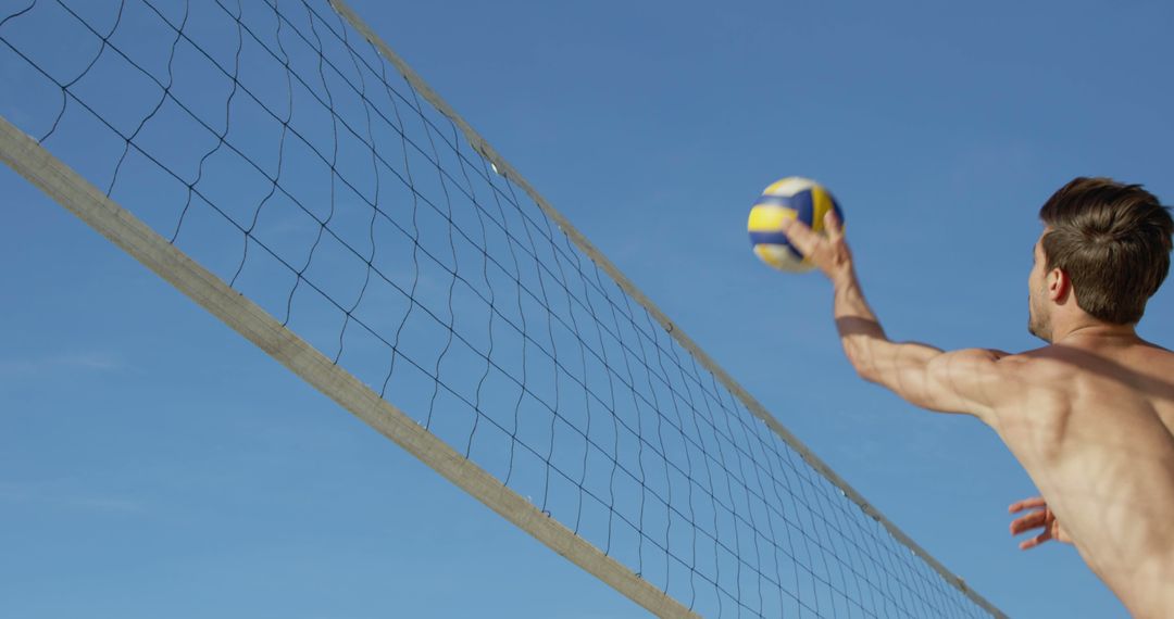 Shirtless Young Man Spiking Volleyball on Outdoor Court - Free Images, Stock Photos and Pictures on Pikwizard.com