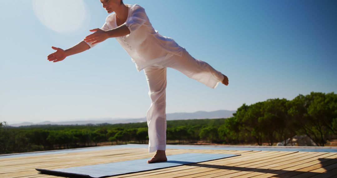 Woman Practicing Yoga Outdoors in Balance Pose on Wooden Deck - Free Images, Stock Photos and Pictures on Pikwizard.com