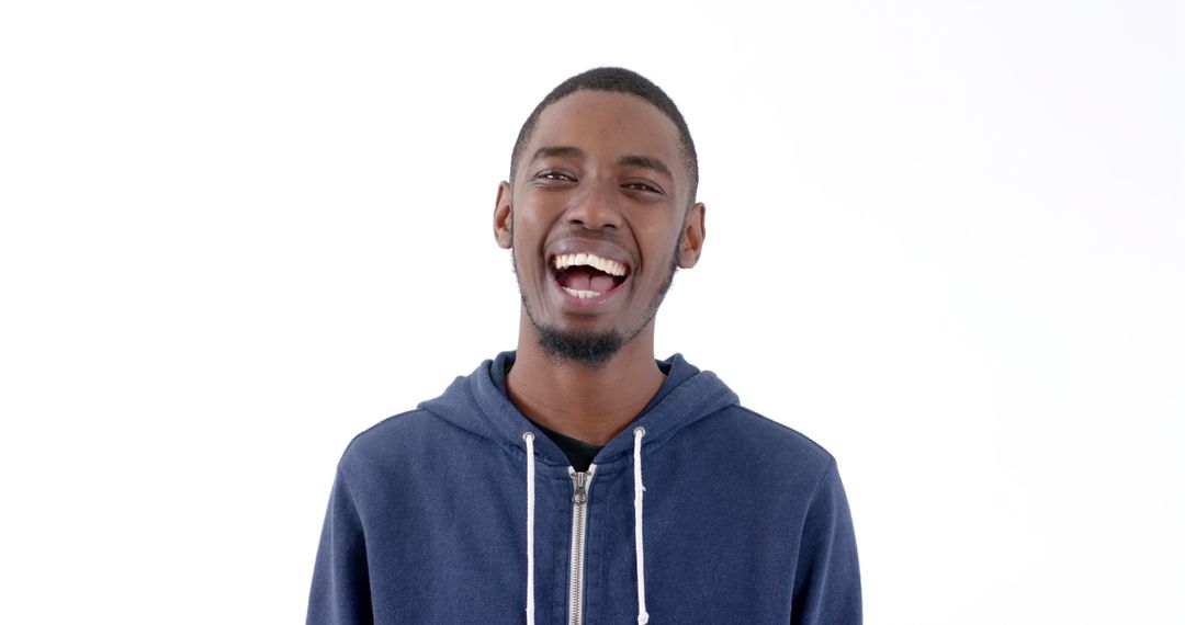 Joyful young man laughing in blue hoodie