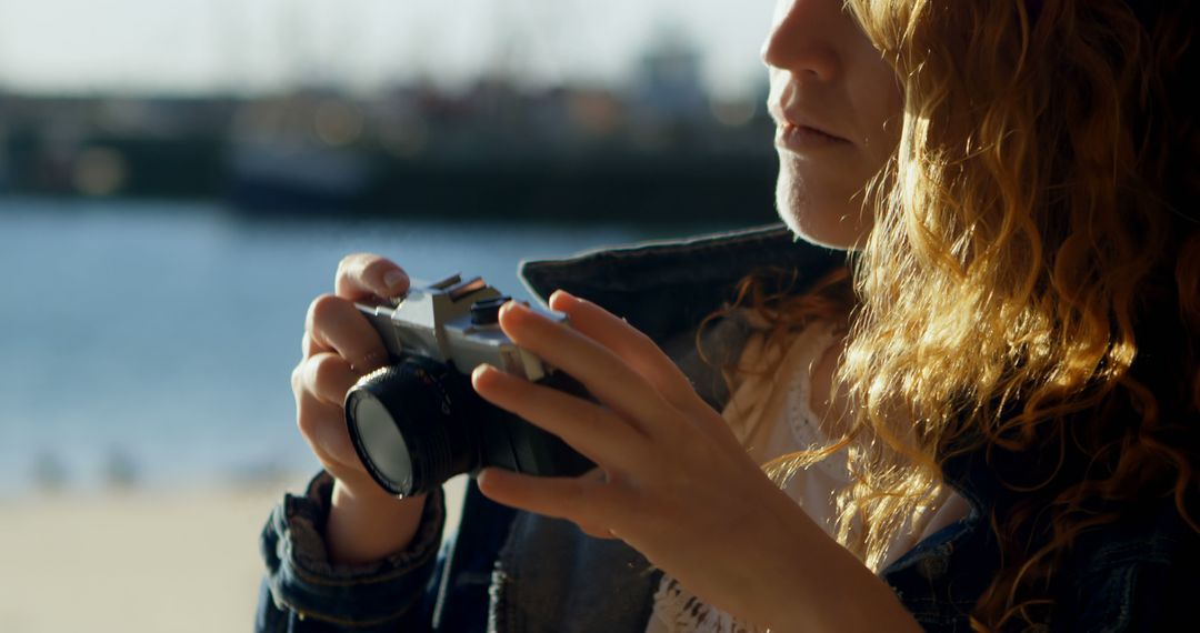 Woman Adjusting Camera, Preparing for Outdoor Photography - Free Images, Stock Photos and Pictures on Pikwizard.com