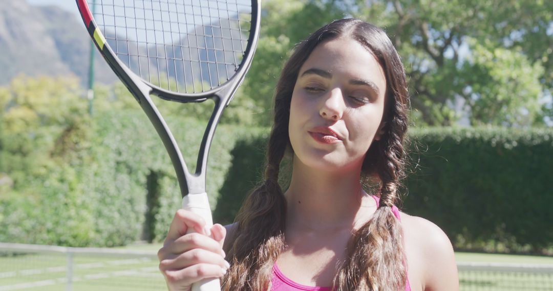 Young Female Tennis Player Holding Racket in Sunny Outdoors - Free Images, Stock Photos and Pictures on Pikwizard.com