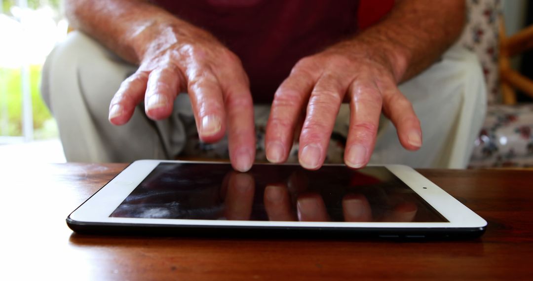 Senior Man Using Tablet Computer with Focus on Hands - Free Images, Stock Photos and Pictures on Pikwizard.com