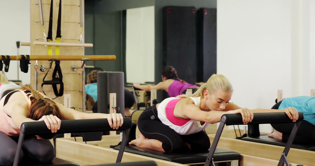 Women Practicing Pilates on Reformer Equipment in Modern Gym - Free Images, Stock Photos and Pictures on Pikwizard.com