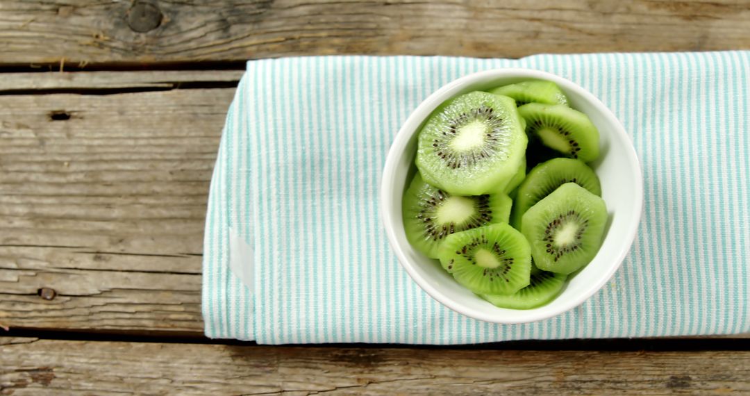 Fresh Kiwi Slices in White Bowl on Wooden Table - Free Images, Stock Photos and Pictures on Pikwizard.com