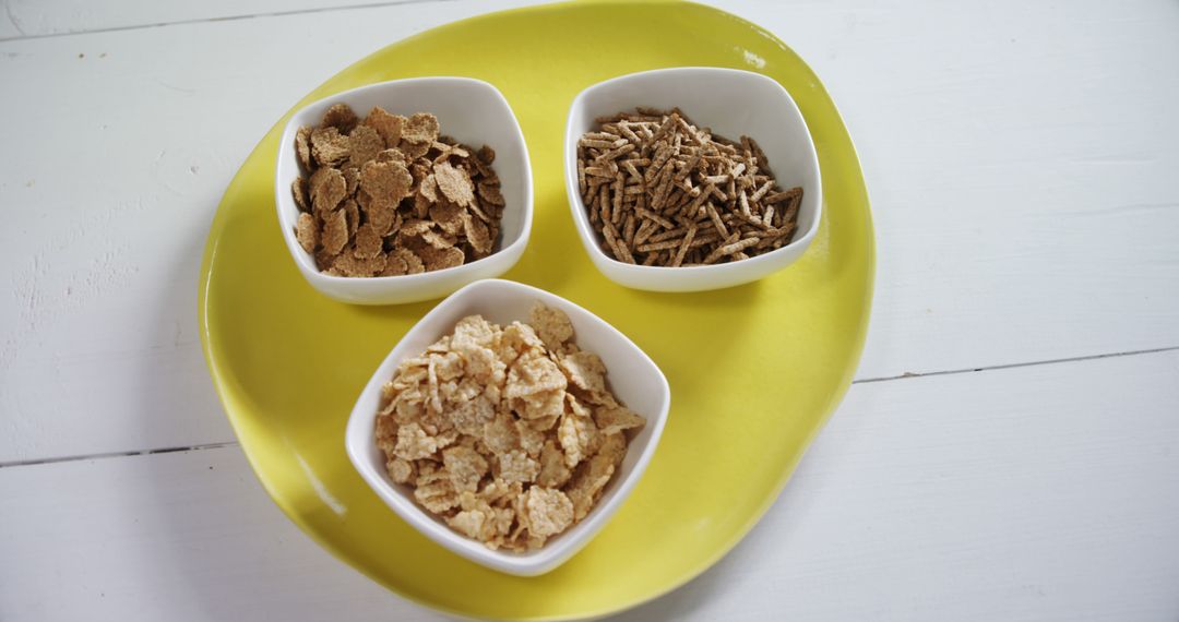 Assorted Breakfast Cereals in Square White Bowls on Yellow Plate - Free Images, Stock Photos and Pictures on Pikwizard.com