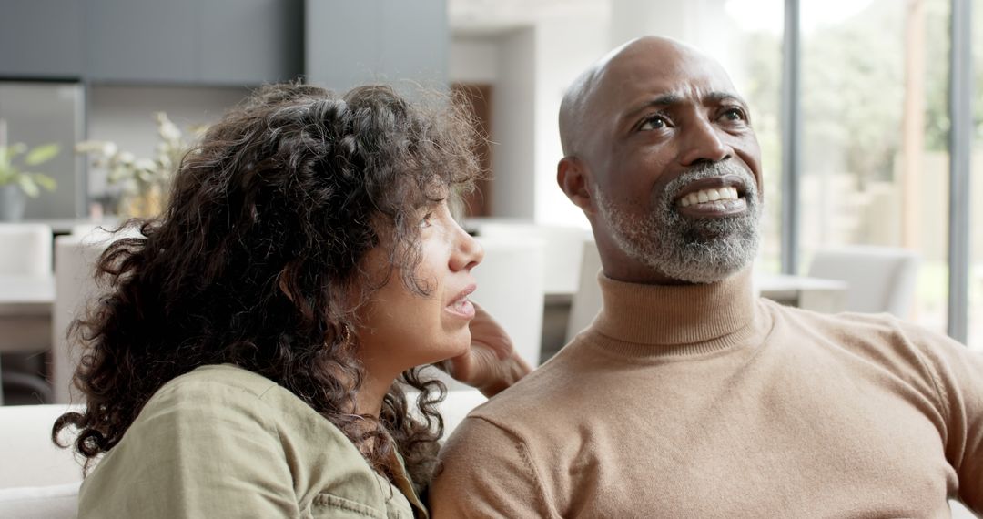 Smiling Biracial Couple Relaxing Together in Modern Home