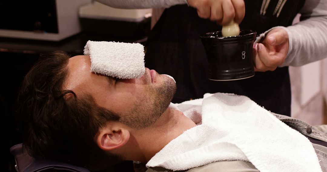 Man Relaxing at Barbershop with Hot Towel Treatment - Free Images, Stock Photos and Pictures on Pikwizard.com