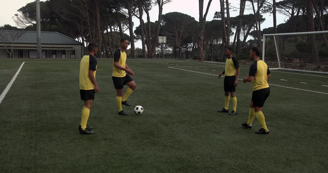 Soccer Players in Yellow Jerseys Practicing Teamwork Techniques