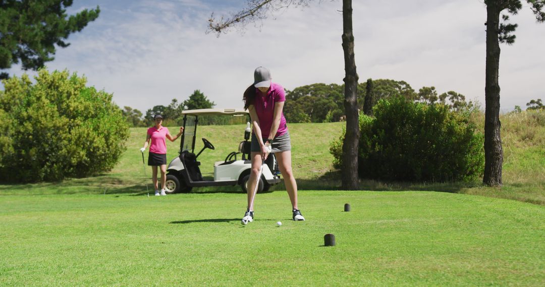 Women preparing for drive on golf course in sunny weather - Free Images, Stock Photos and Pictures on Pikwizard.com