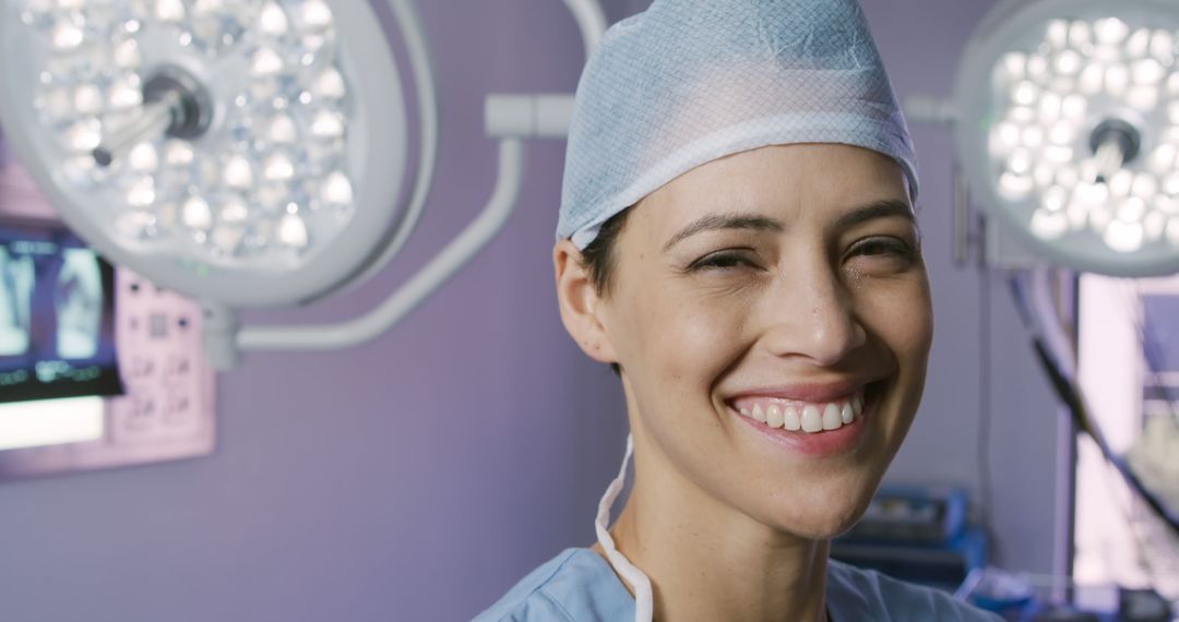 Female Doctor Smiling in Operating Room Under Surgical Lights - Free Images, Stock Photos and Pictures on Pikwizard.com