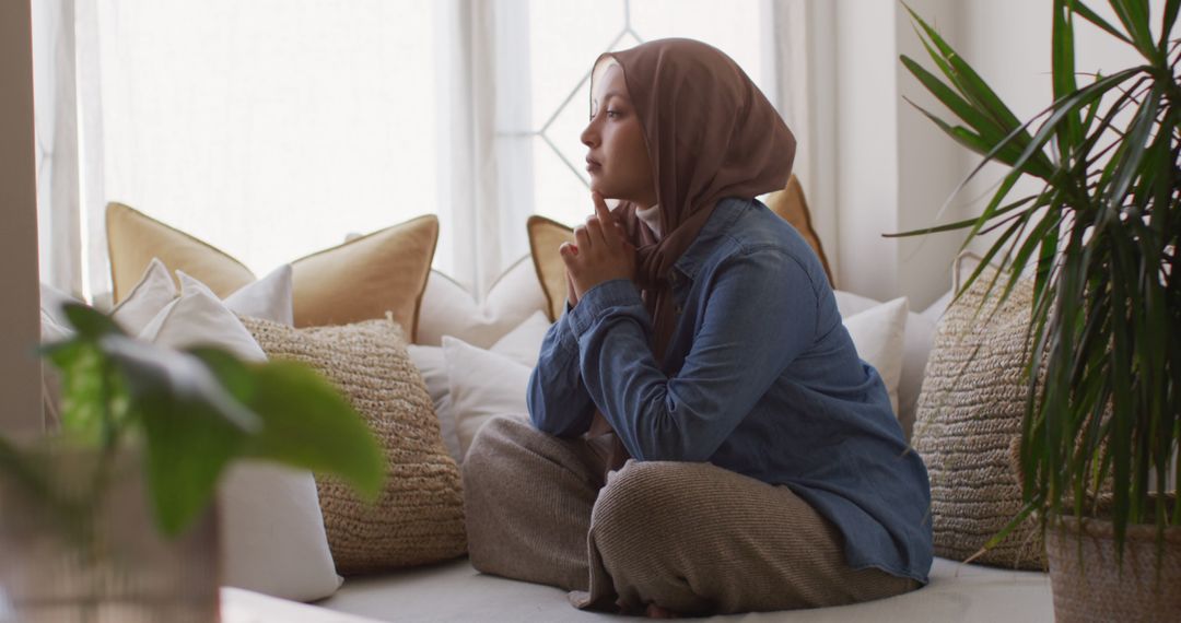 Pensive Muslim Woman Sitting on Couch in Bright Room - Free Images, Stock Photos and Pictures on Pikwizard.com