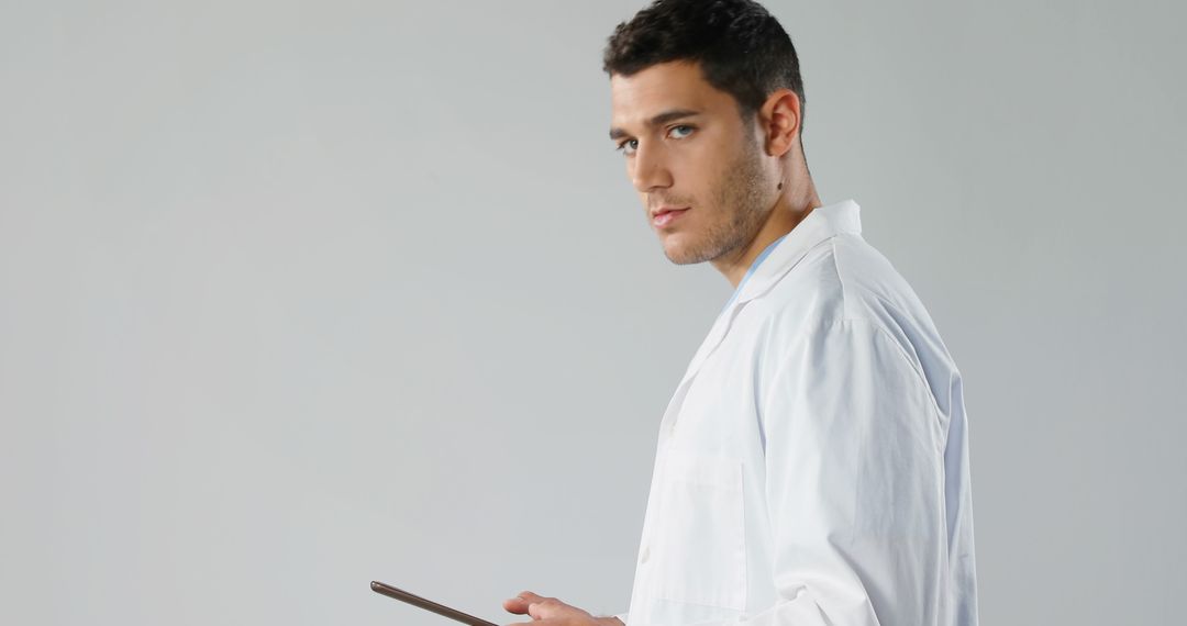 Confident Young Male Doctor with Clipboard Isolated on Gray Background - Free Images, Stock Photos and Pictures on Pikwizard.com