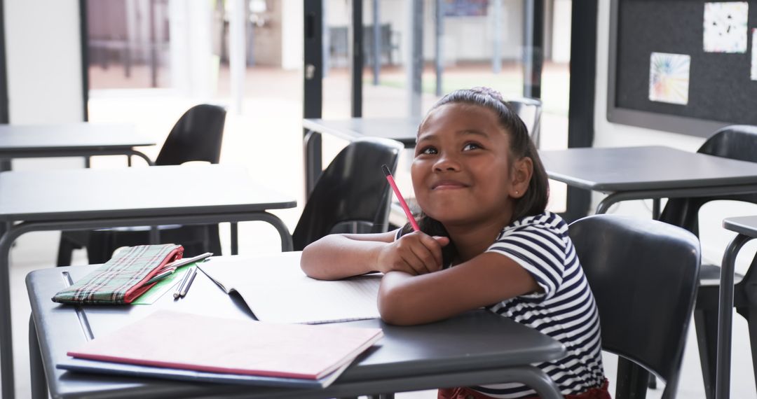 Thoughtful Student in Classroom with Pencil and Notebooks