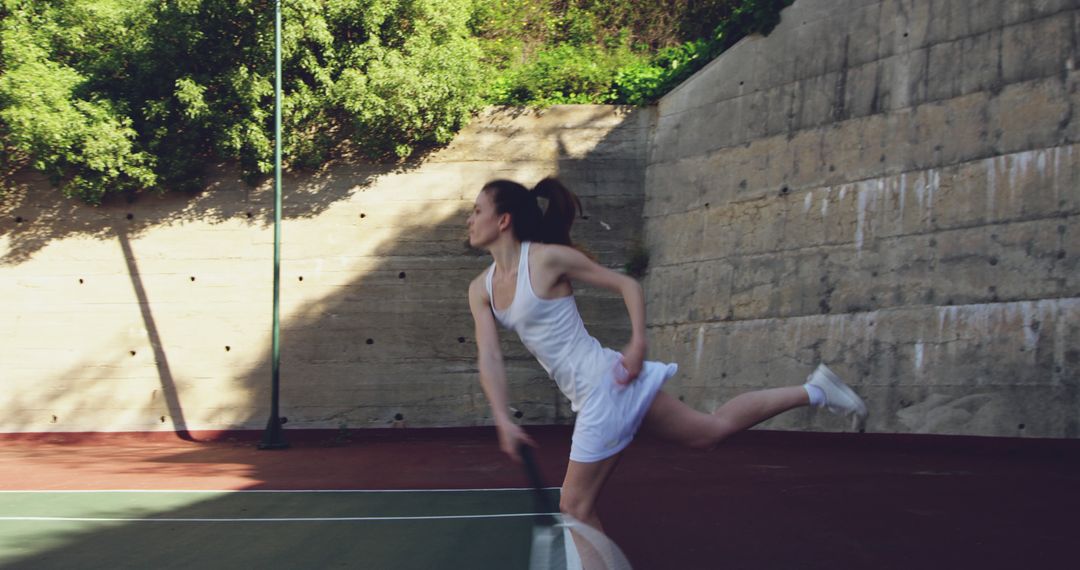 Young Woman Playing Tennis, Capturing Movement on Outdoor Court - Free Images, Stock Photos and Pictures on Pikwizard.com