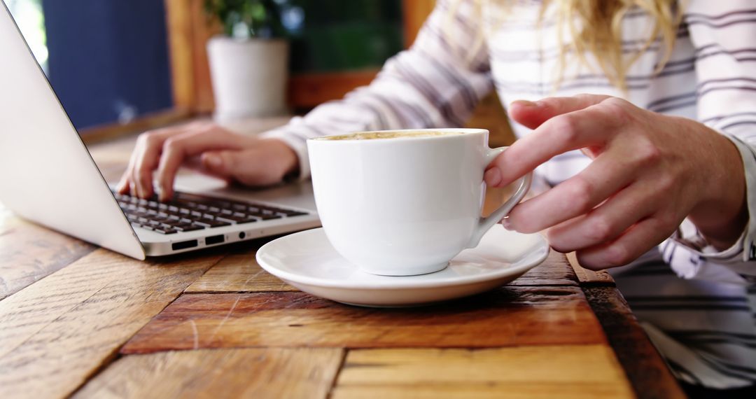 Woman Drinking Coffee While Working on Laptop at Cozy Café - Free Images, Stock Photos and Pictures on Pikwizard.com