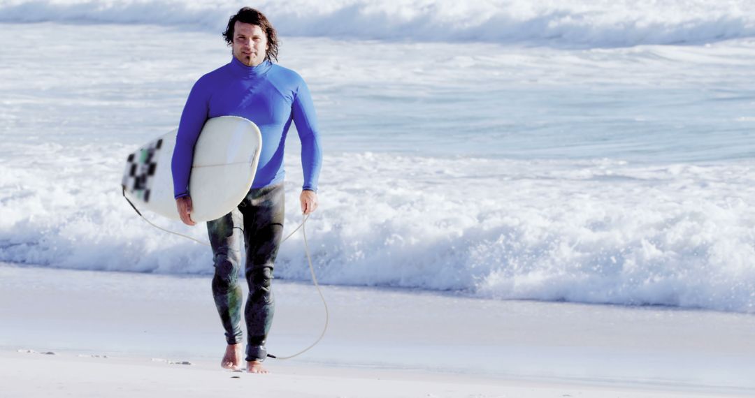 A Caucasian middle-aged man walks on the beach holding a surfboard, with copy space - Free Images, Stock Photos and Pictures on Pikwizard.com