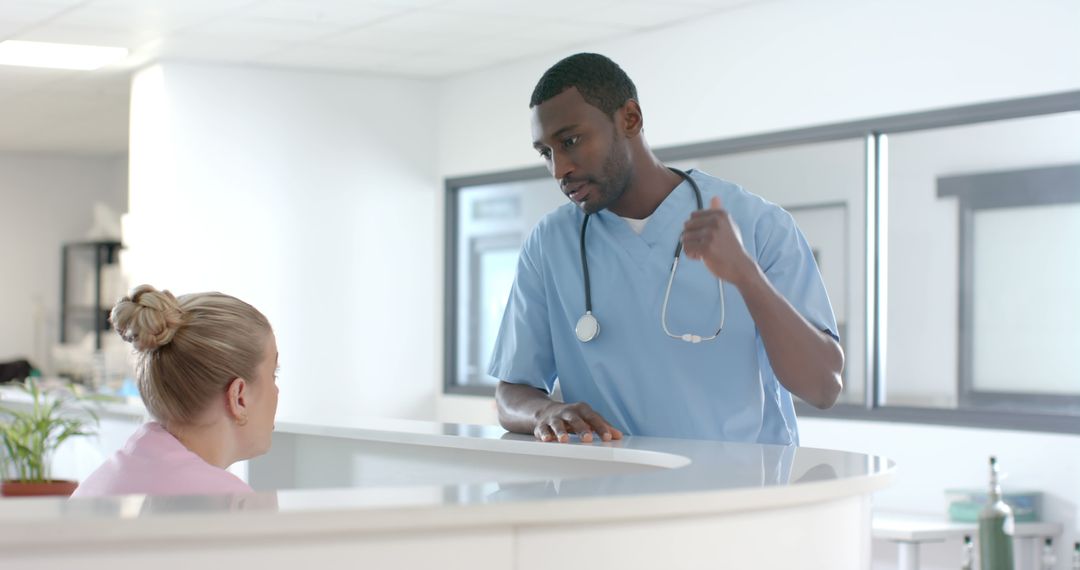 Medical Professional Discussing with Colleague at Reception Desk - Free Images, Stock Photos and Pictures on Pikwizard.com