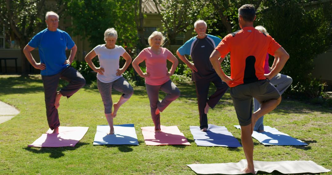 Senior Group Practicing Yoga with Instructor Outdoors