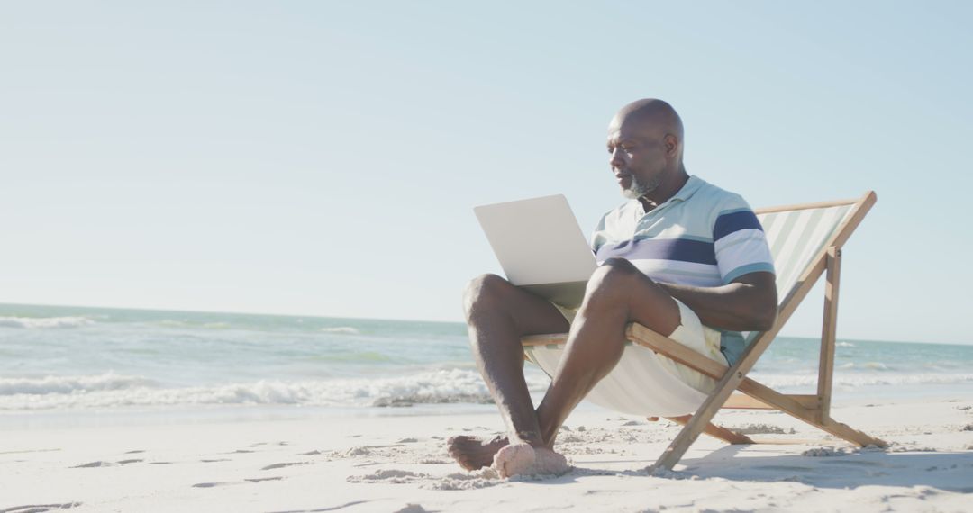 African American Man Working on Laptop at Tropical Beach - Free Images, Stock Photos and Pictures on Pikwizard.com