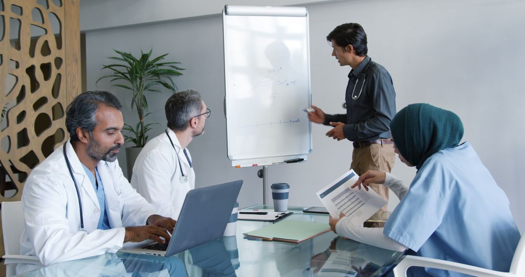 Medical Team Discussing Charts During Meeting in Hospital Conference Room - Free Images, Stock Photos and Pictures on Pikwizard.com