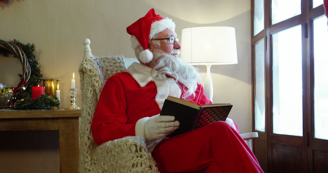 Santa Claus Relaxing with a Book in Cozy Christmas Setting - Free Images, Stock Photos and Pictures on Pikwizard.com