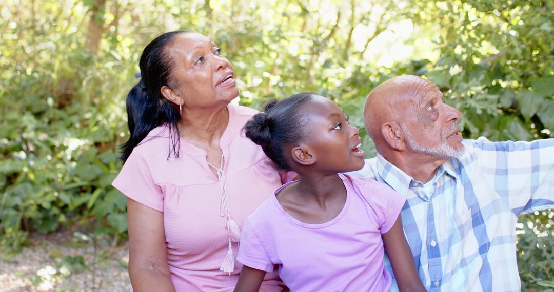 Relaxed Grandparents and Granddaughter Exploring Nature Together